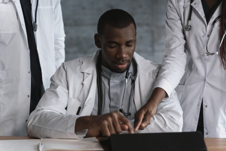 Profissionais de saúde discutem um projeto de pesquisa médica em um ambiente clínico.